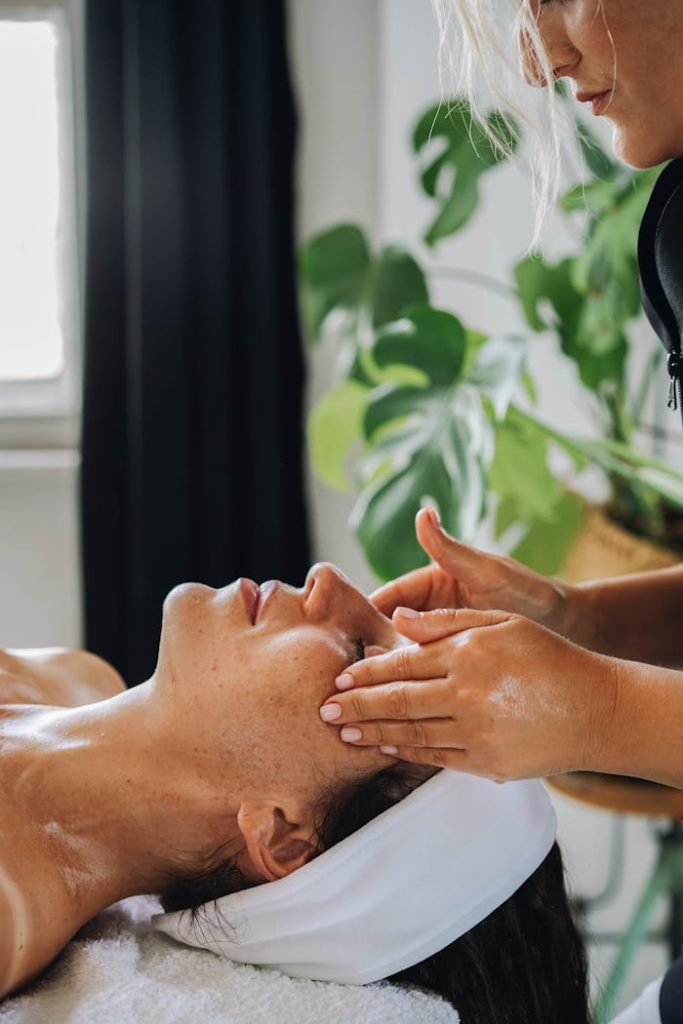 close-up-shot-of-a-woman-having-a-face-massage-9335964 Woman receiving a calming facial massage at a wellness spa.